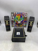 Front view showing two black zippered cassette library album cases and sealed 1999 Grateful Dead calendar with iconic skull and lightning bolt graphic.