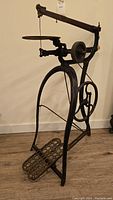 Full view of antique New Rogers scroll saw showing treadle base, frame, wheel, and saw table