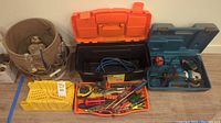 Full lot view showing tool pouch, toolboxes, tool organizer with hand tools, and power drill case
