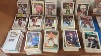 Photo showing stacks of assorted 1980s hockey cards including players in action and team logos