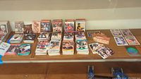 Multiple stacks and piles of hockey cards laid across a wooden surface, showing various card designs and player images.