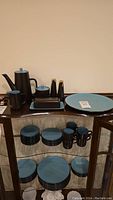 Photo showing the full set of Mikasa Terra Stone Bristol Blue dinnerware including plates, mugs, coffee pot, creamer, covered sugar bowl, and salt & pepper shakers.
