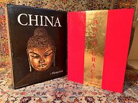 Photo showing the two volume boxed set with the black slipcase featuring a Buddha sculpture on the cover of one volume titled 'China' alongside the red hardcover 'Asia Grace' book by Taschen.
