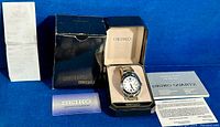 Full lot including Seiko men's wristwatch in original box with original packaging, papers, guarantee card, and sales receipt.