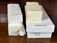 View of white storage boxes labeled 'Topps Hockey 1991' and 'Upper Deck Hockey 92-93' with intact cardboard and no visible damage.