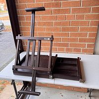 View of easel unfolded on table showing adjustable frame and storage compartments.