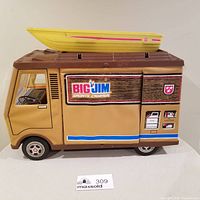 Image of Big Jim Sports Camper toy vehicle with rowboat on roof showing side view with decals.