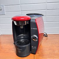 Side angle photo of Bosch Tassimo coffee maker showing the front and control dial.