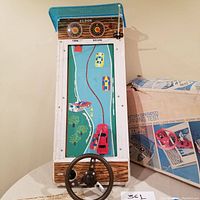 Front view of Eldon battery operated Driving Test tabletop game showing steering wheel, game board graphics with cars and timer/score dials, and original box.