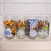 Front view of the four Great Muppet Caper drinking glasses showing colorful character illustrations and logo.