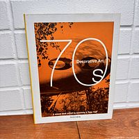 Front cover of the Taschen 1970s Decorative Art Book with orange and white design.