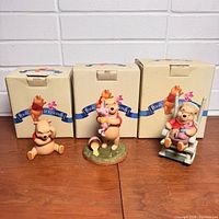 Set of three Winnie The Pooh figurines with original boxes, showing the full lot and packaging.