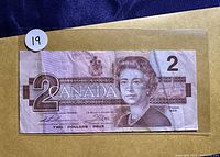Front side of 1986 Canada $2 dollar bill showing Queen Elizabeth II portrait and denomination.