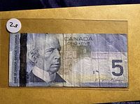 Front side of Bank of Canada $5 bill showing portrait and serial number.