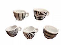 Five unique limited edition Illy espresso cups displayed on white background showing different abstract black and white designs.