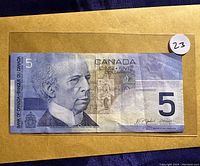 Front side of the $5 Canadian banknote showing portrait of Sir Wilfrid Laurier and Parliament buildings.