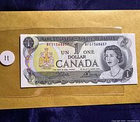Front view of the 1973 Canadian one dollar bill with serial number BFG1568657 showing Queen Elizabeth II and coat of arms.