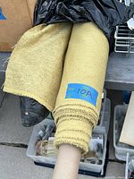 Full roll of yellow/gold woven upholstery fabric on a tube with label 10A, showing approx. 8 yards available.