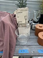 Photo showing boxes of IKEA SVALKA champagne flutes with clear glass compote dish in front.