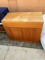 Top and front view of wooden Mid-Century Modern Danish cabinet showing two doors and worn top surface.
