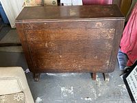 Table folded with drop leaves down showing the top surface and side profile.