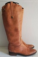 Full side view of tan leather knee-high boot showing smooth leather upper, low heel and toe shape.