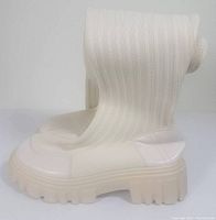 Side view of one boot showing knit upper and chunky sole.