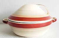 Side view of covered tureen showing red and cream wedding band stripes and side handles.