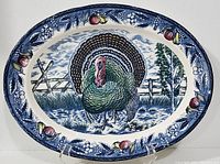 Front view of the large oval ceramic platter showing the central turkey image and blue grapevine border.