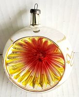 Photo showing the concave reflective center of the glass ornament with red and yellow colors.
