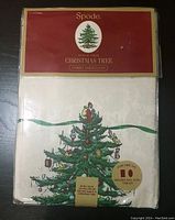 Front label of Spode Christmas Tree fabric tablecloth packaging, showing the brand name, Christmas Tree series, and product type.