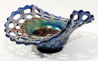 Side view of cobalt blue carnival glass bowl showing basket weave pattern and open edge design with cut-outs.