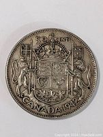 Front side of the 1942 Canada 50 cents silver coin showing the detailed Canadian coat of arms with the date and denomination.