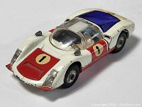 Front top angle of white and red Porsche Carrera 6 die cast car showing paint wear and driver detail.