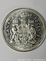 Image of the obverse side of the 1961 Canadian 50 cent silver coin showing detailed coat of arms, date, denomination, and country name.