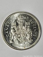 Image of the obverse side of the 1963 Canada Silver Half Dollar coin showing the detailed royal coat of arms with lions, crown, and date.