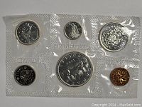 View of six 1965 Canadian coins in sealed plastic packaging, showing both front and back of coins including silver and copper colored ones.