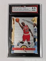 Front view of graded Michael Jordan 1996-97 Upper Deck 'Jordan Greater Heights' special insert card showing card in protective slab with 8.5 grade.