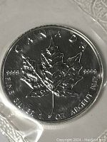 Close-up front view of the sealed silver coin showing maple leaf and purity markings.
