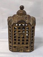 Front view of the antique cast iron still bank showing building facade and bank lettering on roof.