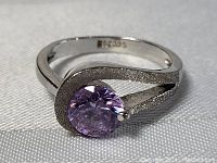 Close-up front angle showing amethyst and textured sterling silver setting with visible 925 marking inside band.