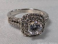 Close-up of ring front showing large center crystal and surrounding double halo of smaller crystals on sterling silver band.