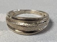 Close-up of the sterling silver hammered ring showing textured and smooth areas.