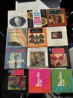 Top view of 13 vinyl record album covers arranged in a grid showing various classical, polka, gospel and big band music records.