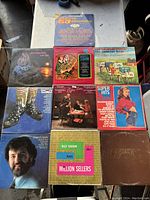 Photo showing Lot of 10 vintage vinyl records arranged in 2 rows on a table surface, various genres and artists visible on album covers.