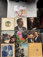 Photo showing all 9 vintage vinyl record albums laid out in three rows of three, featuring various portraits and illustrations on covers