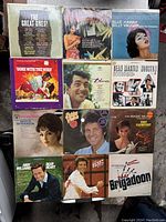 Lot of 12 vintage vinyl records laid out showing album covers with classic artists and colorful designs.