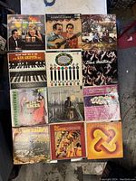 Photo of all 12 vinyl records arranged in a grid showing album covers with various artists and designs.