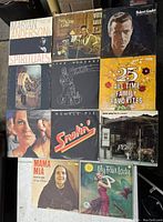 Photo showing 11 vintage vinyl records with varied covers featuring different artists and genres.