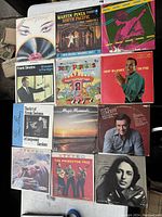 Photo of total 11 vintage vinyl records laid out, showing album cover art and titles